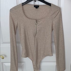 Beige nude bodysuit with a half zipper.